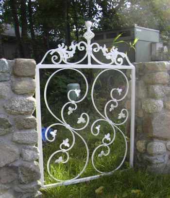 This 36 inch wide iron gate with forged iron top scroll imported from England.  The two center scrolls are imported from Italy.  This gate was made for a memorial rock wall at a residence in Friday Harbor. The white paint makes the gate show well against the rock and with the dark trees in the background.  white_gatec-02.jpg