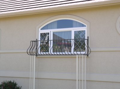 This project had some unique challenges.  The customer wanted to add some personality to the outside of their Tuscan Villa style home.  We designed the Mediterranean balcony style  railings for the windows.  The challenge was how to secure the railing.  The siding and window molding was stucco with foam backing, which would not hold lag bolts, and would cause a risk of moisture seeping into the siding causing dry rot to the wood sheeting.  We designed trellis legs that were set in concrete footings, instead of bolting to the house.
